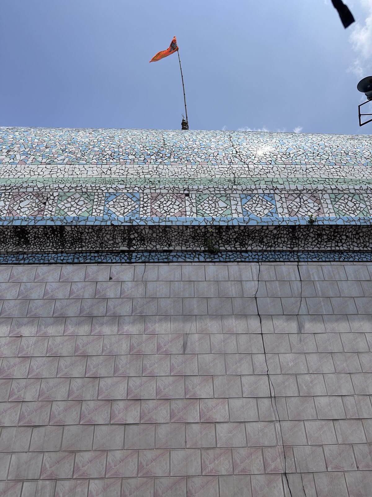 Blue-and-white tiled dome with a saffron flag
